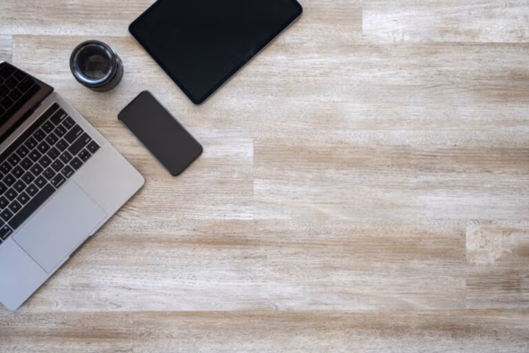 Aufgeräumter Schreibtisch mit Laptop und Smartphone