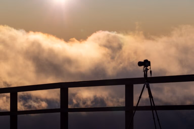 Kamera auf Stativ vor weitem Himmel